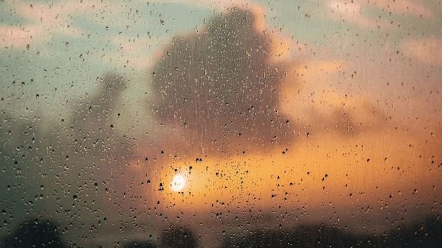 Gotas de chuva numa janela ao entardecer